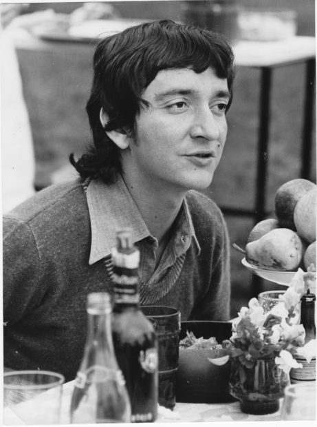 Black and white photo of a young man with a mullet.