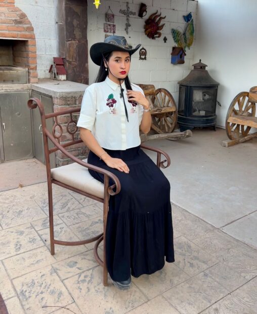 Dámaris Bójor is seated in a courtyard.